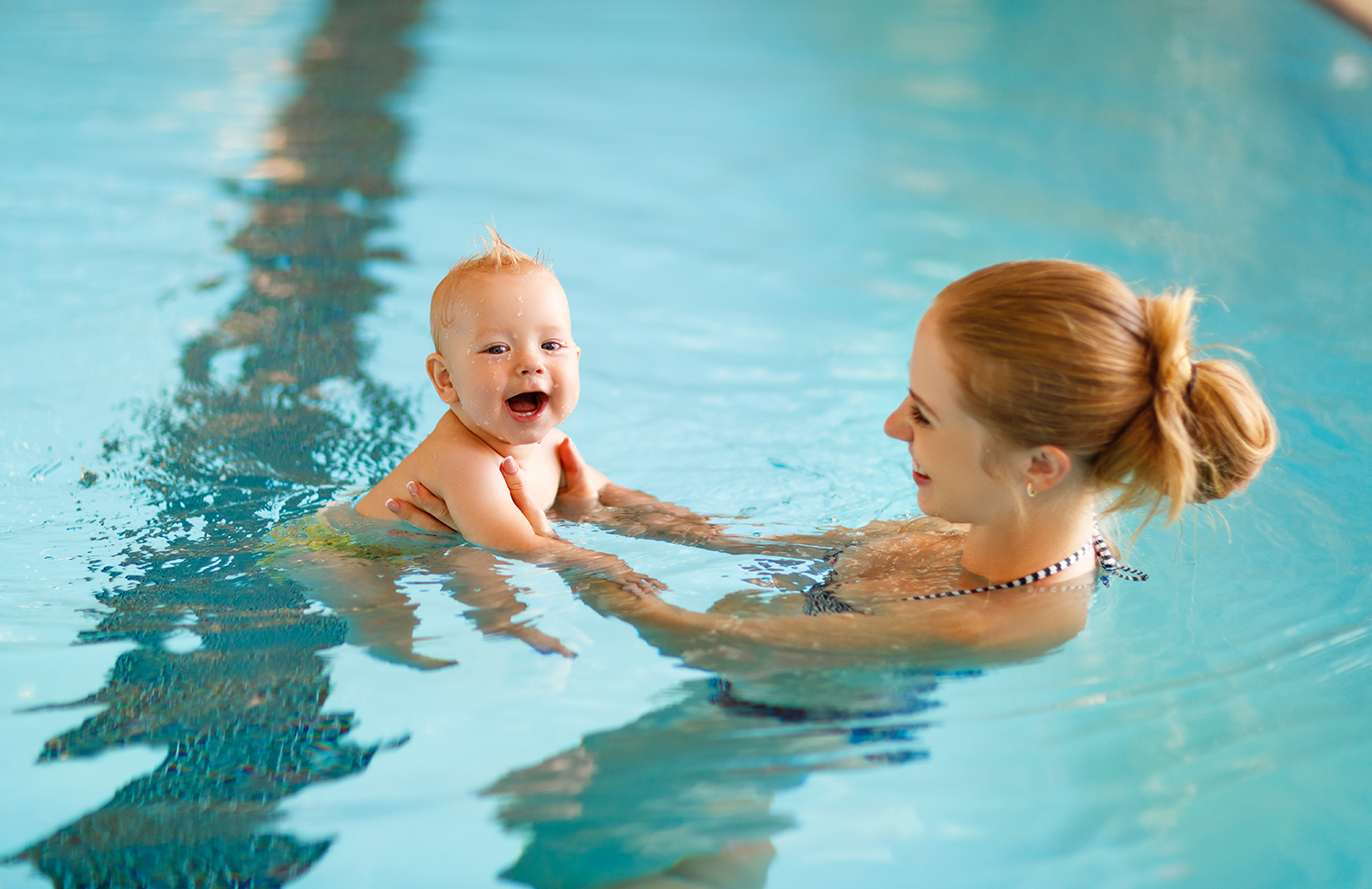 Frau schwimmt mit Baby