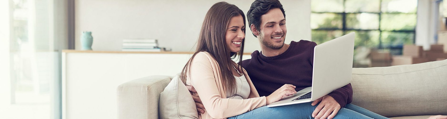 Junges Paar mit Laptop auf Sofa