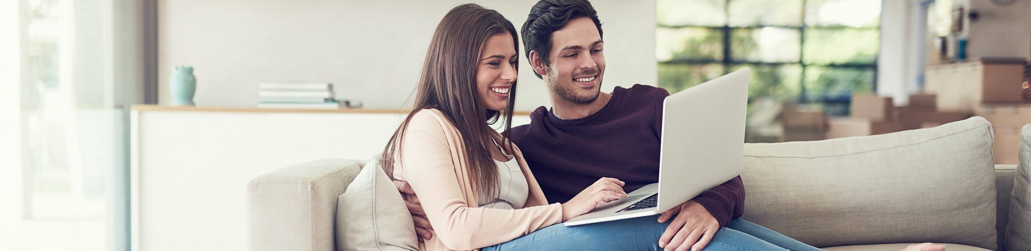 Junges Paar mit Laptop auf Sofa