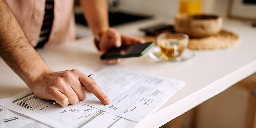 Foto: Mann prüft Unterlagen auf einem Tisch