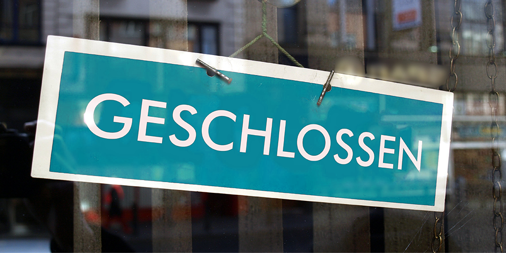 Geschlossen-Schild hinter einer Fensterscheibe