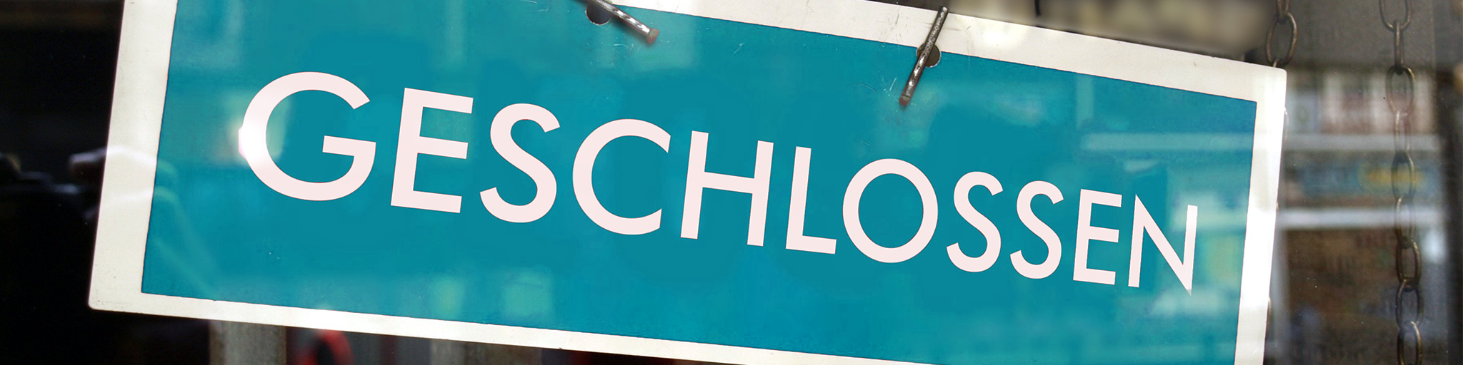 Geschlossen-Schild hinter einer Fensterscheibe